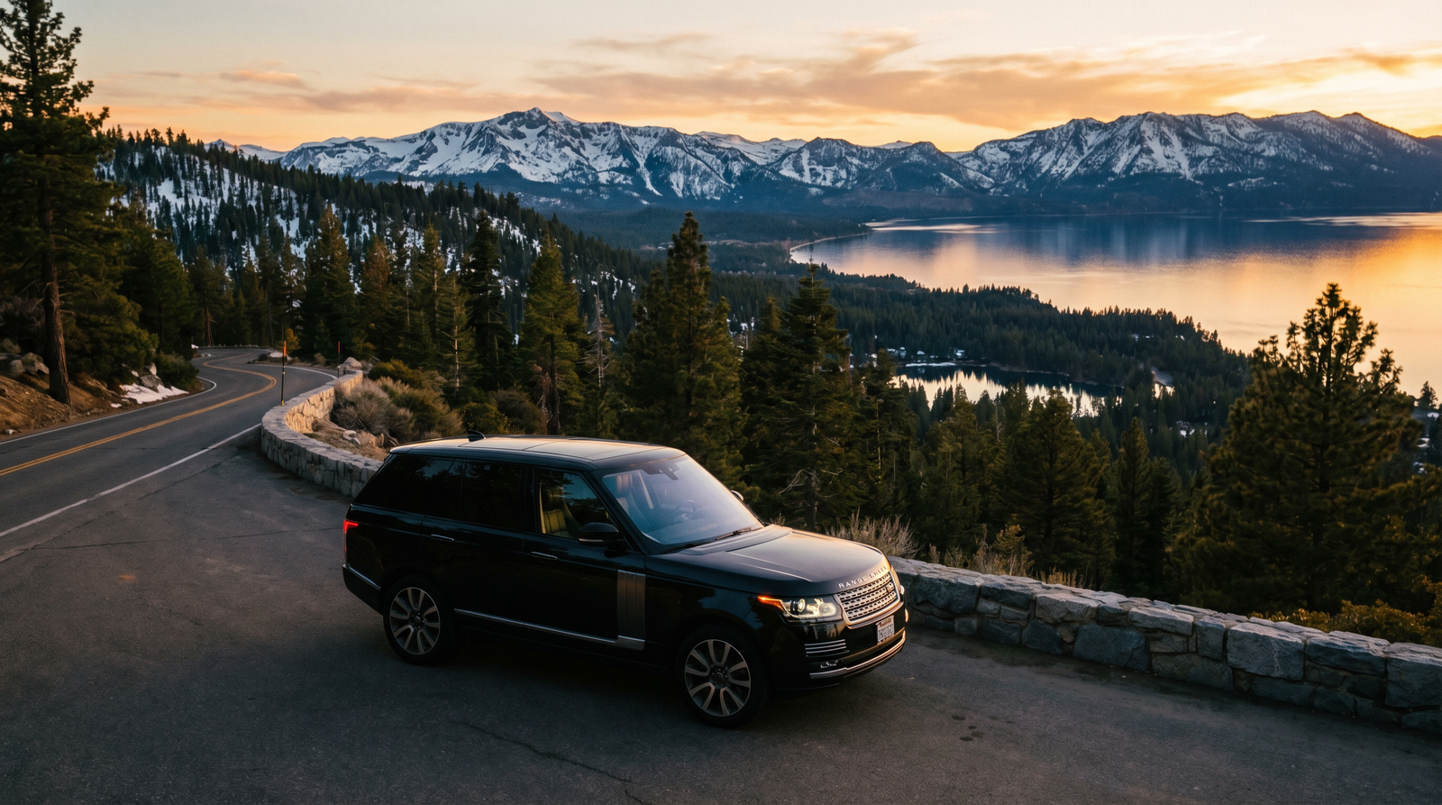 Black SUV overlooking Lake Tahoe and the Sierra Nevada at dusk